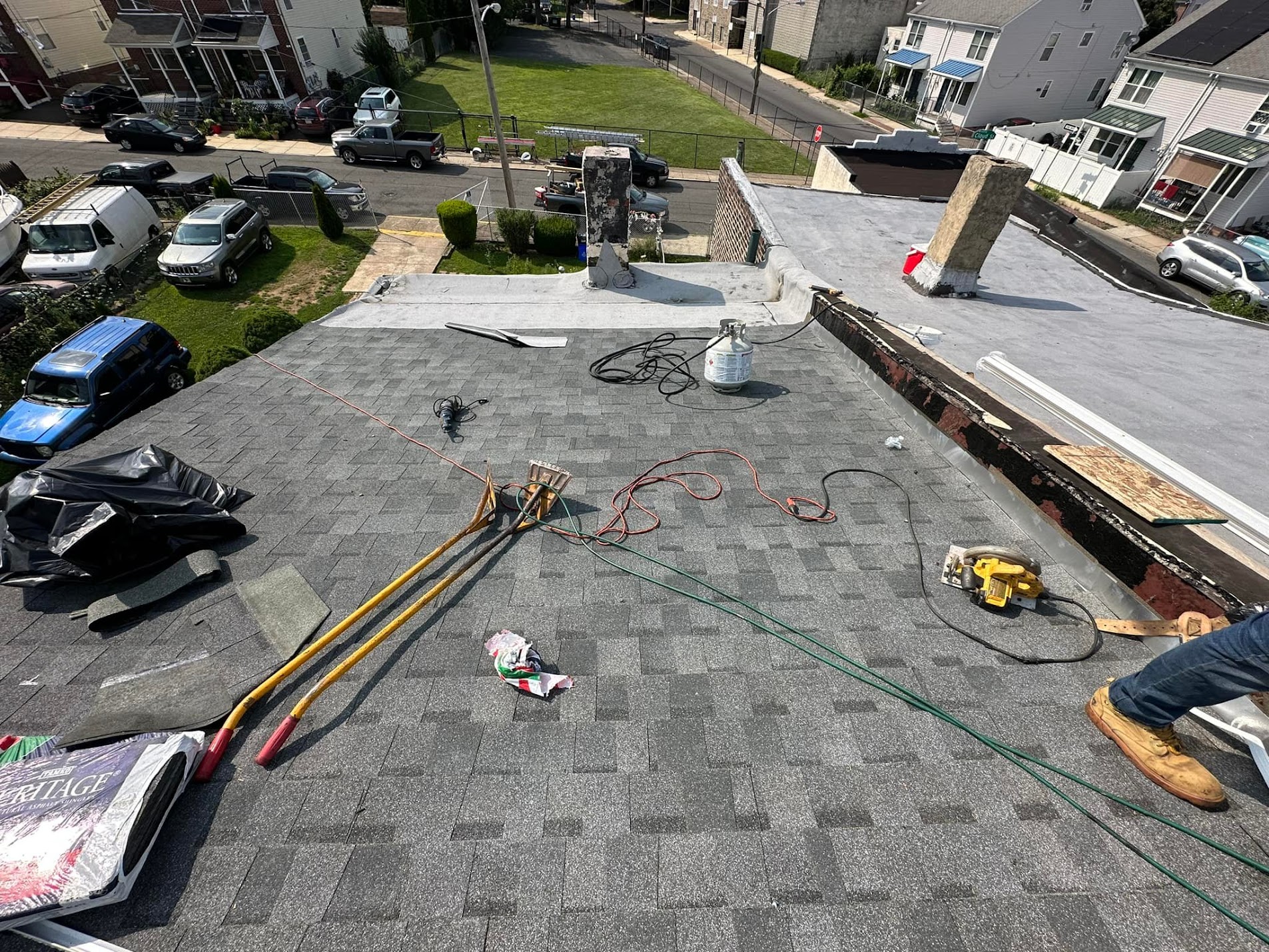 Shingle and flat roof installation in progress