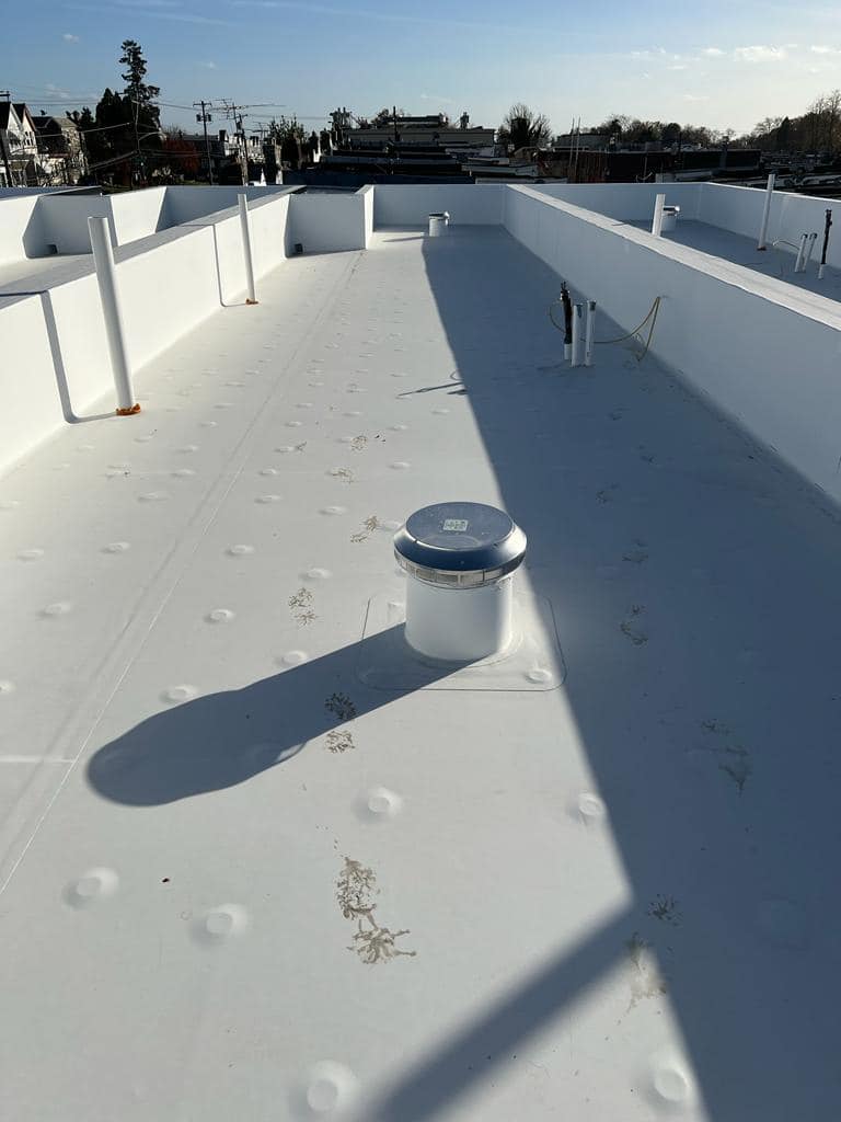 White TPO flat roof membrane installation