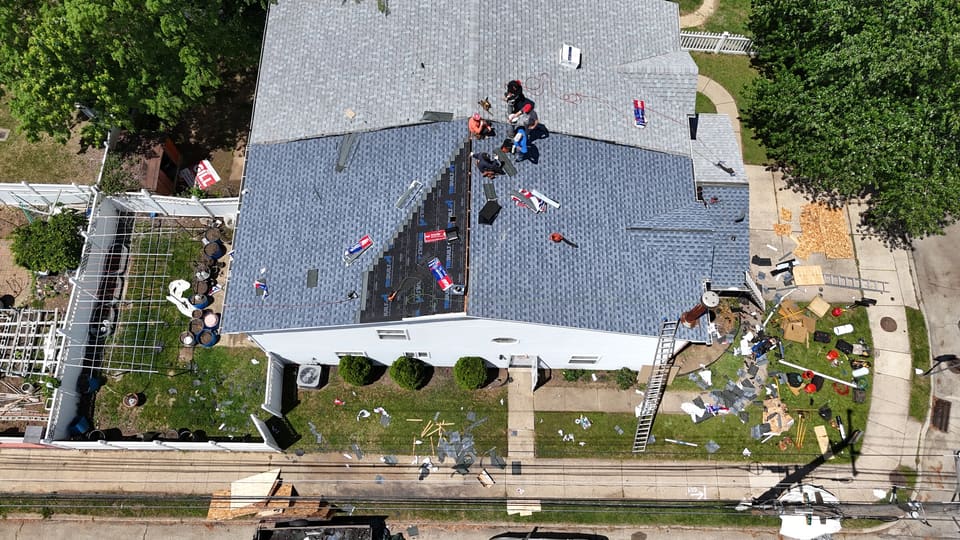 Blue grey shingles going on a large roof, crew working the slope