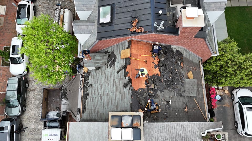 Drone view of a city twin with the old shingles half torn off