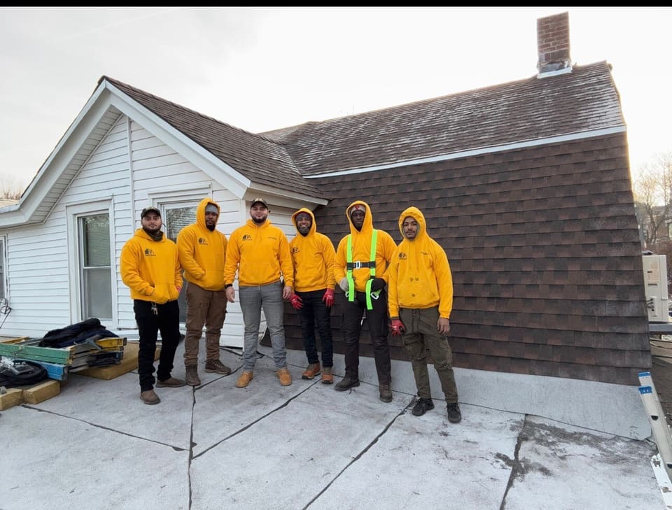 The AP Roofing crew on a roof in yellow hoodies