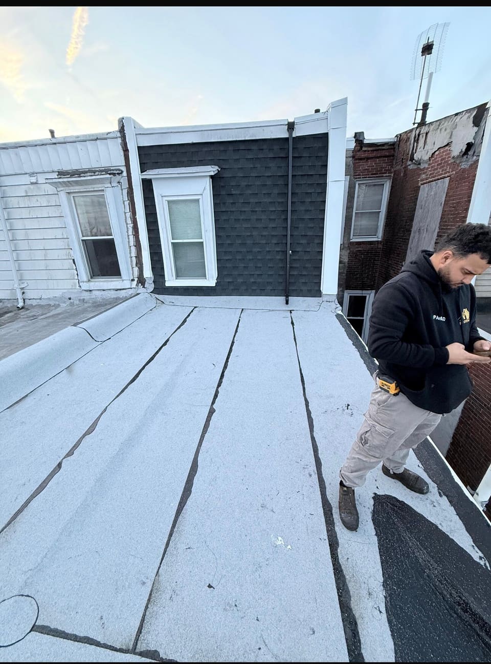A roofer laying base sheet on a flat roof