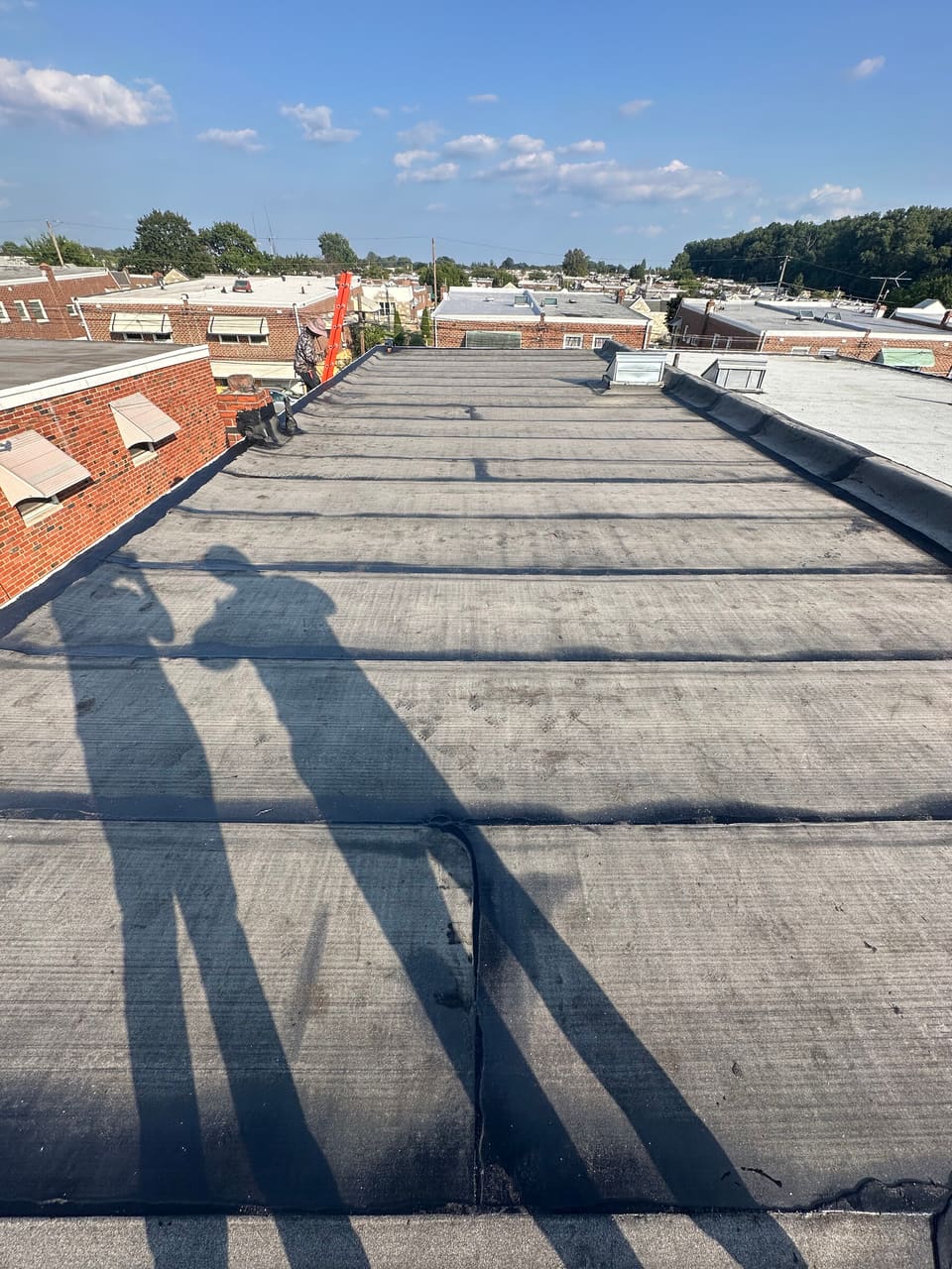 A new flat roof membrane with the crew shadows across it