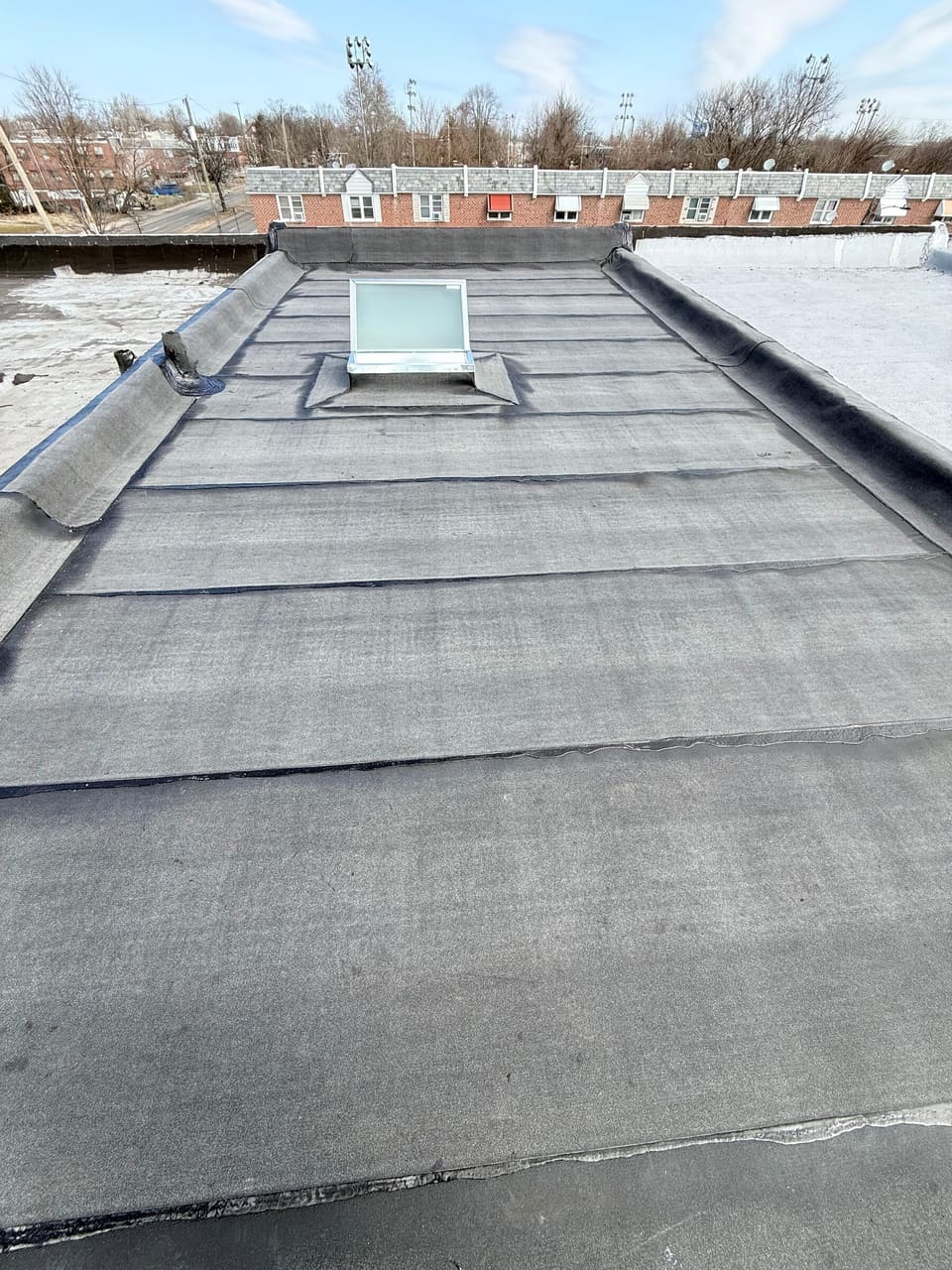 A finished modified bitumen flat roof with a skylight