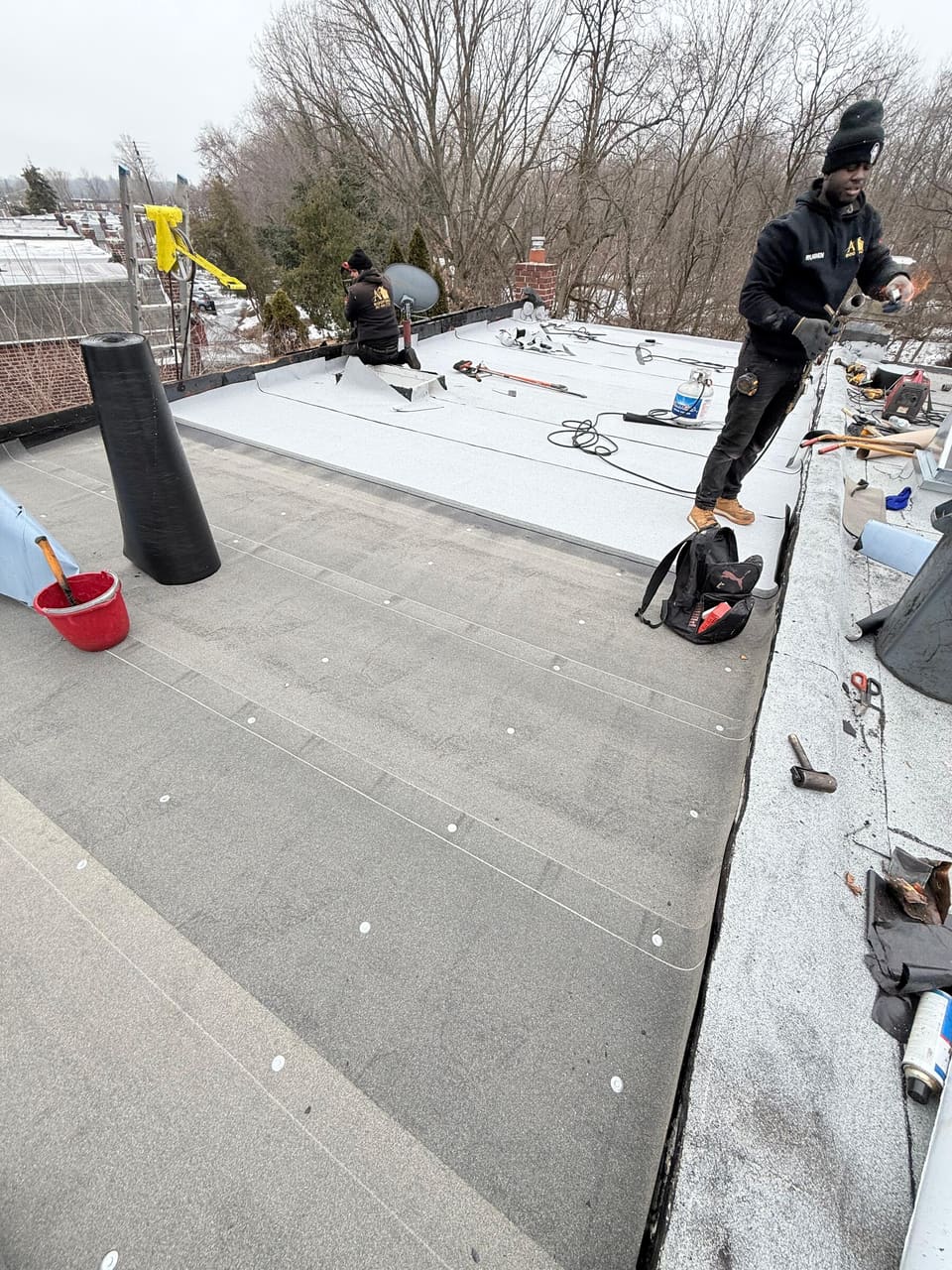 Crew finishing a white membrane flat roof