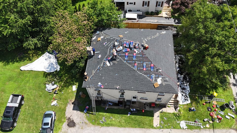 New shingles going on the hip roof, bundles still on the slopes
