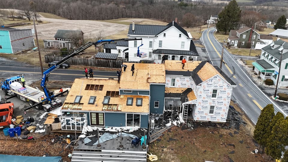 A crane setting material on a large house under construction