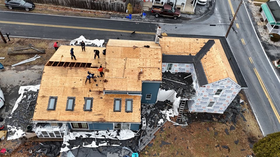 Drone view of a large house under construction, roof decking going on