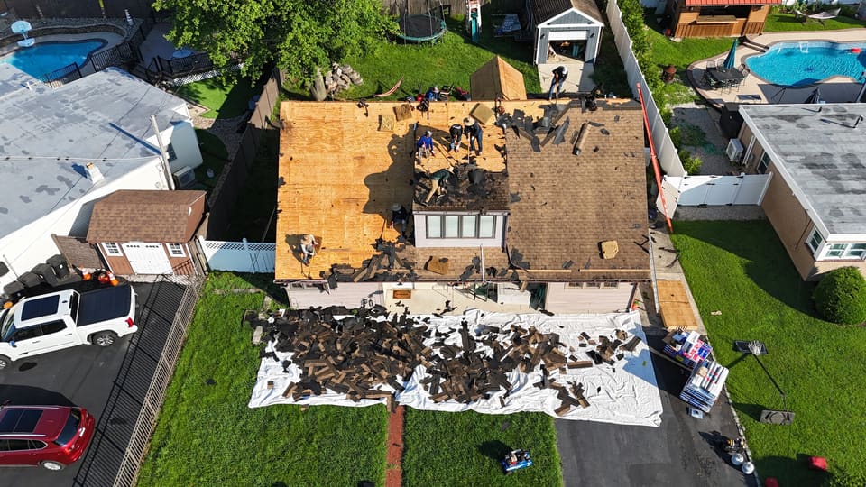 Drone view of a roof being torn off between two pools