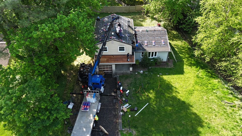 A crane truck delivering material to the split level roof
