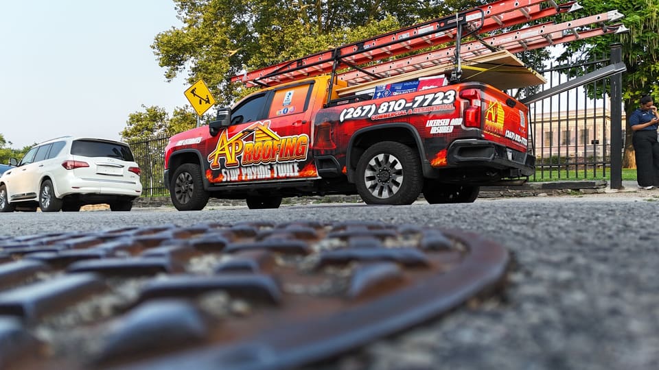 A low angle of the AP Roofing truck from the street