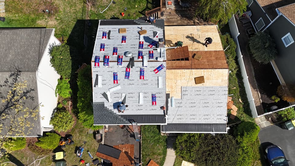 Underlayment and shingle bundles across a twin home roof